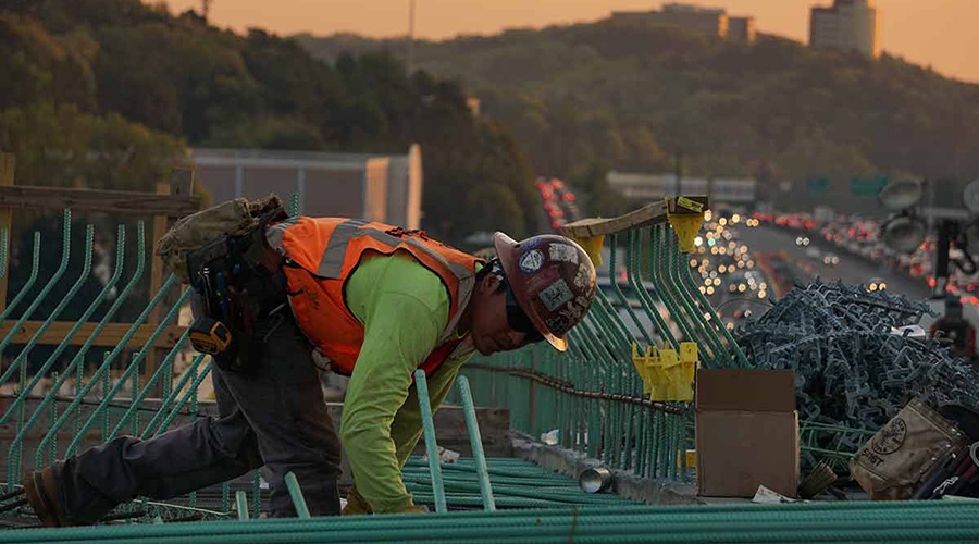 Roofer wearing a safety hat on a roof at sunset