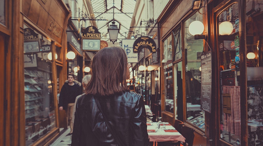 Young woman walking past retail shops on Small Business Saturday