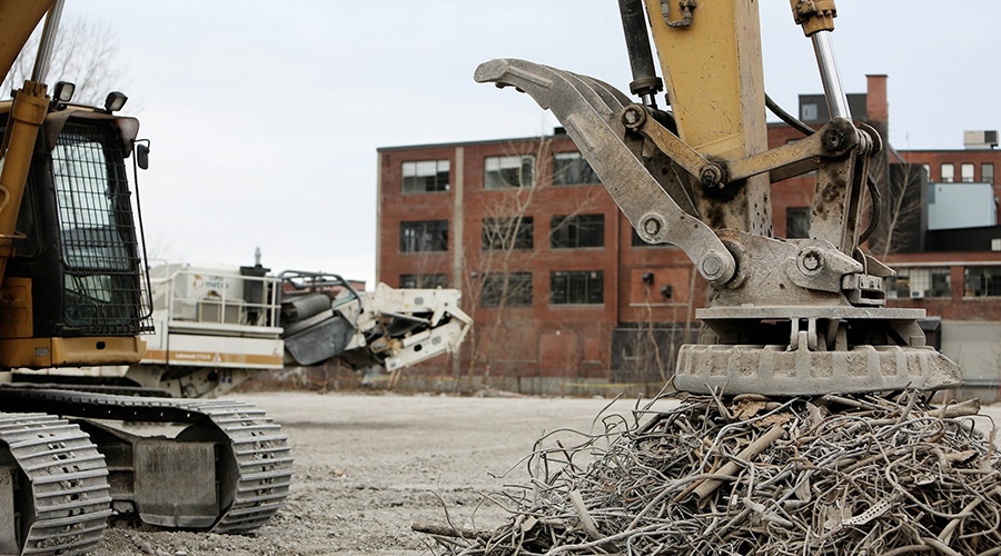 Excavator pressing down on a pile of scrap metal