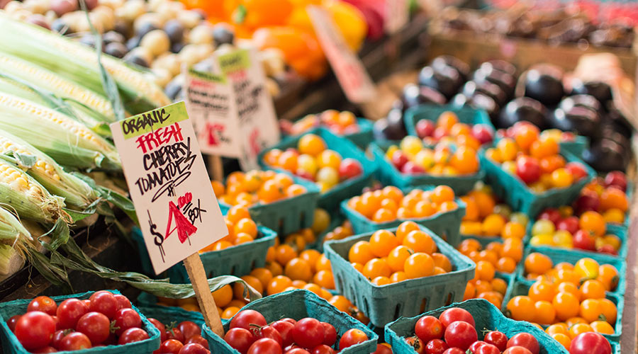 Boxes of organic red and yellow cherry tomatoes at a farmers' market